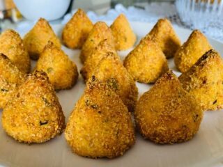 Coxinha de frango low carb crocante e dourada servida em prato branco