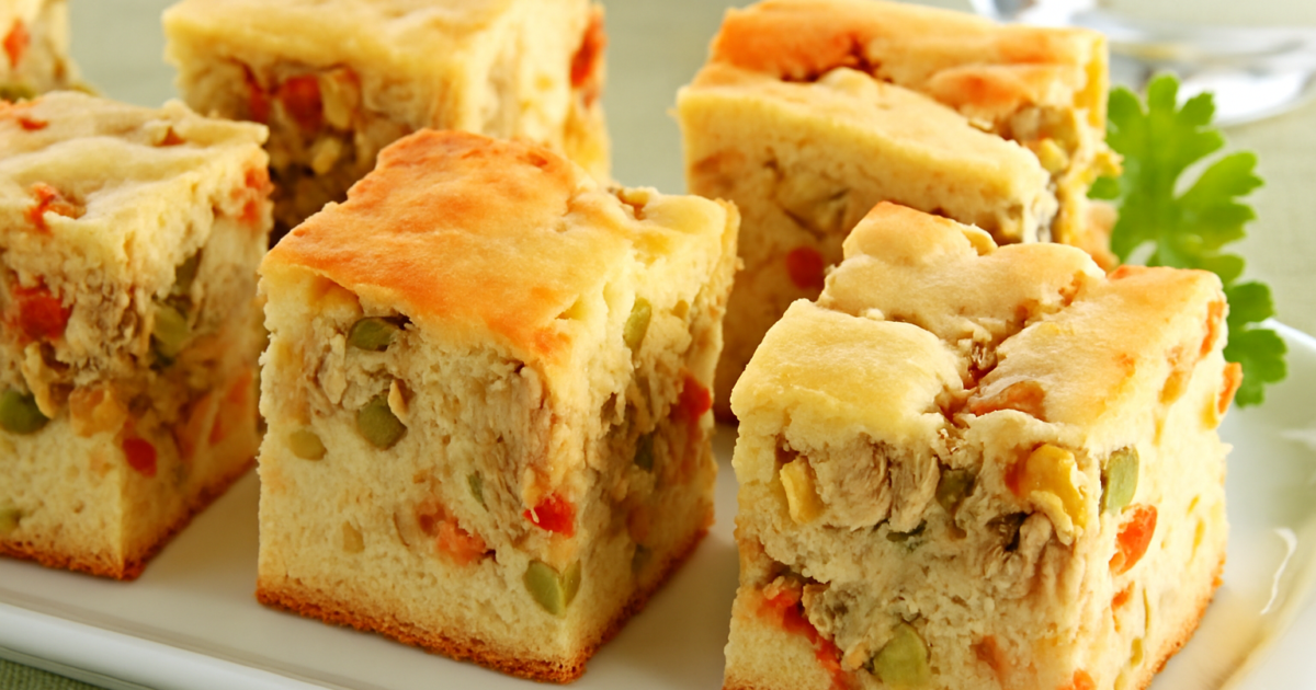 Fatia de torta de frango fit servida em prato branco com salada