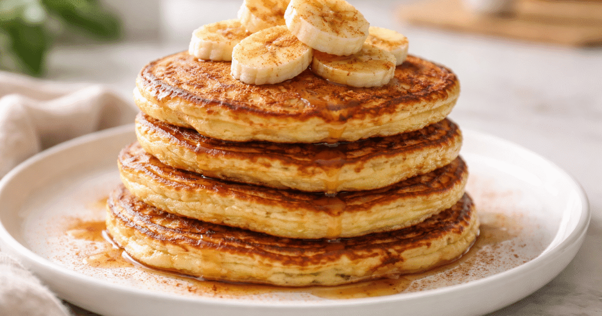 panqueca de banana low carb dourada empilhada com rodelas de banana em prato branco